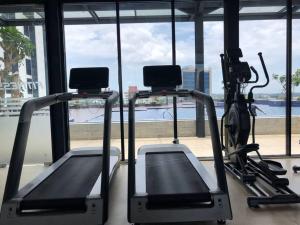 een fitnessruimte met 2 loopbanden en uitzicht op het water bij Sea View One Bedroom Apartment In Bluhen Tower in Batam Center