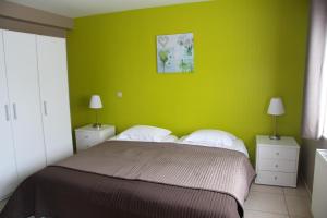 1 dormitorio con una pared verde, 1 cama y 2 lámparas en Relais Charlemagne Sca, en Herve