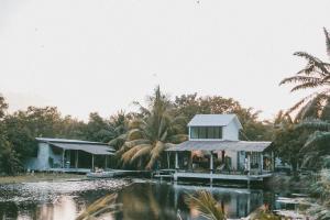 a house on a dock next to a body of water at Matchoon Homestay in Ban Noen Klang