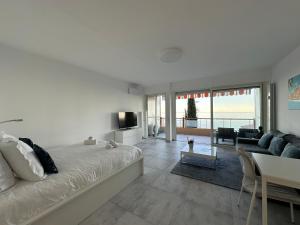 un salon avec un grand lit et un canapé dans l'établissement Le Vigia-vue mer-terrasse-climatisation-parking, à Menton 25 autres photos