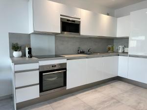 een witte keuken met witte kasten en een wastafel bij Le Vigia in Menton