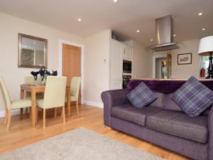 ein Wohnzimmer mit einem lila Sofa und einem Tisch in der Unterkunft 2 Bed in Edinburgh 83967 in Roslin