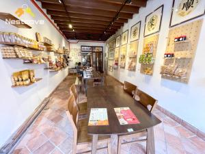 um restaurante com uma mesa e cadeiras de madeira em SOINN Jonker Guesthouse By Nestcove em Malaca