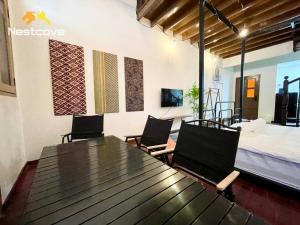 um quarto com uma mesa e cadeiras e uma cama em SOINN Jonker Guesthouse By Nestcove em Malaca