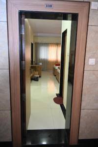 Una puerta que conduce a una habitación con dormitorio en HOTEL PRITAM PARK, Jalgaon, Maharashtra, en Jālgaon
