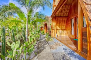 a wooden house with a porch and palm trees at Kira Cottages in Nusa Penida