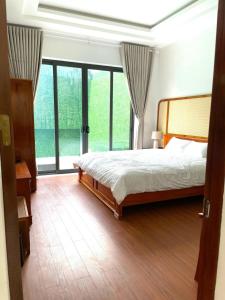 a bedroom with a bed and a large window at Cao Son Hotel in Bắc Quang