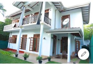 a white house with windows and a balcony at Sanasuma Villa in Bentota