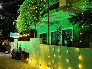 a green building with christmas lights in front of it at SHEEBA'S HOMESTAY in Cochin