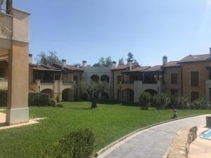 a row of houses with a grass yard at The Flowers - Apartments with Private Garden in Residence with Pool in Manerba del Garda