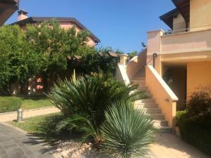 a stairway leading to a house with a palm tree at The Flowers - Apartments with Private Garden in Residence with Pool in Manerba del Garda