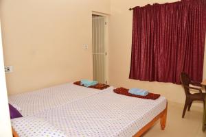 two beds in a room with a red window at SHEEBA'S HOMESTAY in Cochin