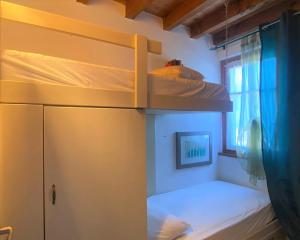 a bunk bed in a room with a window at The Flowers - Apartments with Private Garden in Residence with Pool in Manerba del Garda