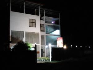 a white building with a sign in front of it at night at Vintop Hotel & Homestays Gampaha in Gampaha