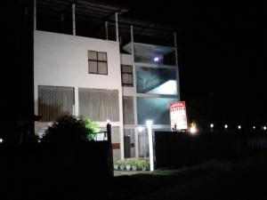a white building with a sign in front of it at night at Vintop Hotel & Homestays Gampaha in Gampaha