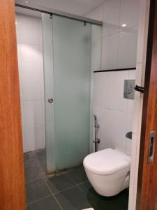 a bathroom with a toilet and a glass shower door at HOTEL BLACK & WHITE in Visakhapatnam
