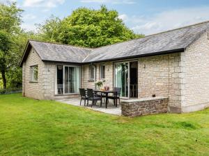 a stone house with a patio and a table at 2 Bed in St. Mellion 87713 in St. Mellion