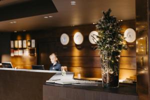 a woman sitting at a counter in a restaurant with a christmas tree at Marco Polo Hotel Gudauri in Gudauri