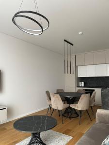 a dining room with a black table and chairs at Dineikos apartamentai in Druskininkai