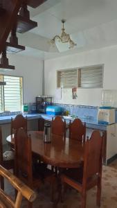 a kitchen with a wooden table and chairs in a kitchen at KALAYAAN INN in Port Barton