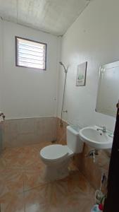 a bathroom with a toilet and a sink at KALAYAAN INN in Port Barton