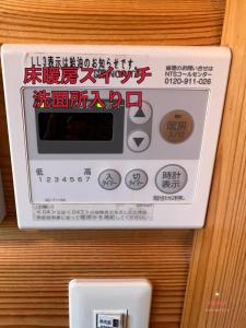 een elektronisch apparaat op een muur met tekst erop bij 山中湖湖畔高級ログハウス 充電富士168 in Yamanakako