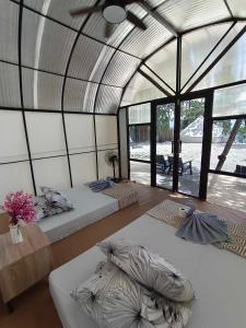 um quarto com duas camas num quarto com janelas em Siquijor Glamping Village em San Juan