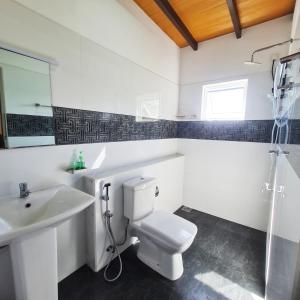 a bathroom with a white toilet and a sink at Che Resort in Digana