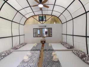 um quarto com 3 camas num quarto com tecto em Siquijor Glamping Village em San Juan