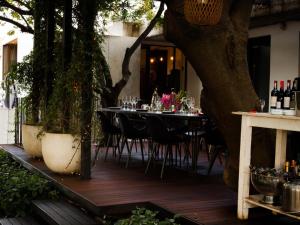 a table and chairs on a deck with a tree at Milner Fashion House in Pretoria