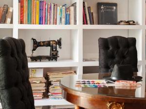 een kamer met een tafel, een naaimachine en boeken bij Milner Fashion House in Pretoria