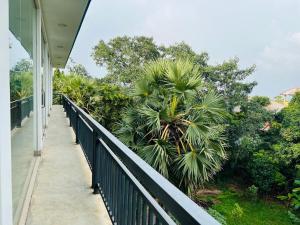 een balkon van een huis met een palmboom bij Esha Beach Resort Rooms in Trincomalee