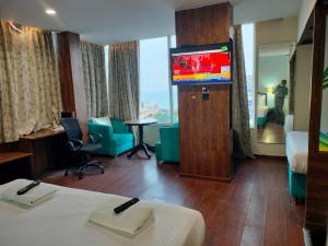 ヴィシャカパトナムにあるHOTEL BLACK & WHITEのテレビ、ベッドが備わるホテルルームです。