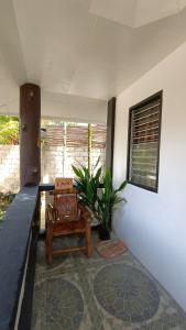 a room with a chair and a table and a plant at KALAYAAN INN in Port Barton