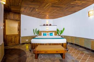 a bedroom with a bed and a wooden ceiling at ama Stays & Trails Eden Farms Sapphire, Goa in Goa