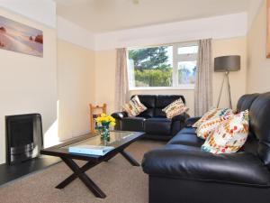 a living room with a leather couch and a coffee table at 2 bed in Bude 58818 in Bude