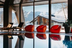 um quarto com cadeiras vermelhas e vista para uma montanha em Marco Polo Hotel Gudauri em Gudauri