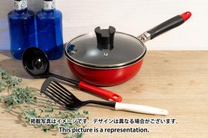 a red pot with a spatula and a whisk and a knife at MAT WASEDA in Tokyo