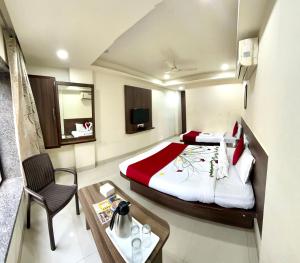 a hotel room with a bed and a table at Hotel Sai Chhatra in Shirdi