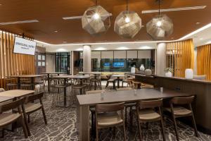 a restaurant with tables and chairs and a bar at SpringHill Suites Minneapolis Maple Grove/Arbor Lakes in Maple Grove