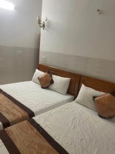 duas camas sentadas uma ao lado da outra num quarto em Hưng Phát Hotel em Phu Yen