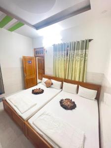 a bedroom with two beds with white sheets at Hưng Phát Hotel in Phu Yen