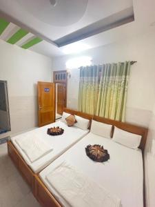 um quarto com 2 camas e lençóis brancos em Hưng Phát Hotel em Phu Yen