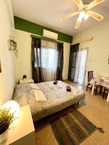 a bedroom with a bed and a ceiling fan at Past or Tail rooms in Larnaka