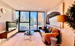 Highrise best location 2baths في ملبورن: غرفة معيشة مع أريكة ونافذة كبيرة