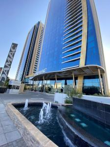 DAMAC Riyadh - Luxury Apartments في الرياض: مبنى فيه نافورة امام مبنى