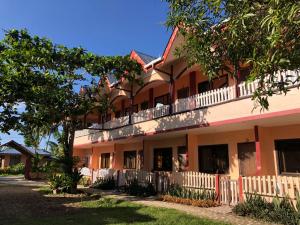 um edifício de apartamentos com varanda e árvores em JBR Tourist Inn - Port Barton em Itaytay