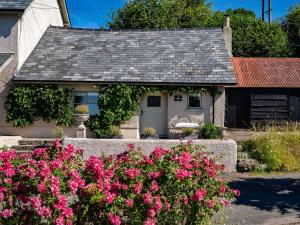 una casa con flores rosas delante de ella en 1 bed in Exbridge 85219, en Skilgate