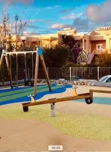 a playground with two swings in a park at Solon Apartments in Maleme