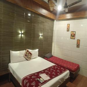 a small bedroom with a bed and a red blanket at Hotel Geetanjali St Bus Stand Panvel in Panvel